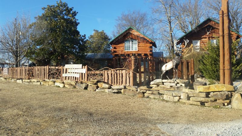 A Rustic Log Cabin Surrounded By Forested Hills
