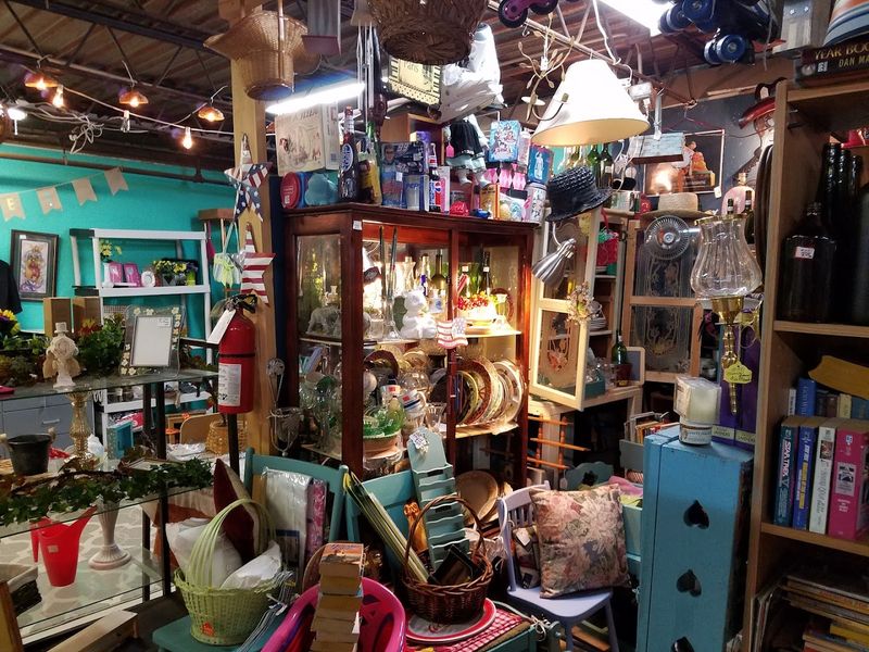 Shelves Filled With Pyrex Patterns, Tin Signs, And Toy Memories