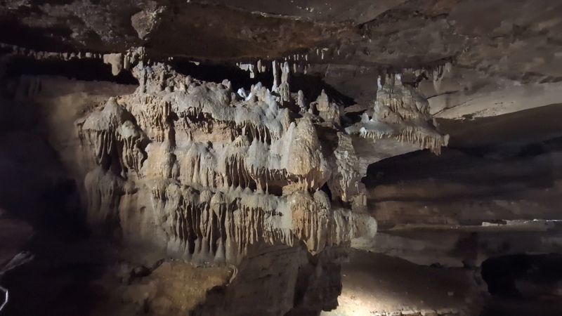 The Cave Features Extensive Limestone Formations And Narrow Chambers