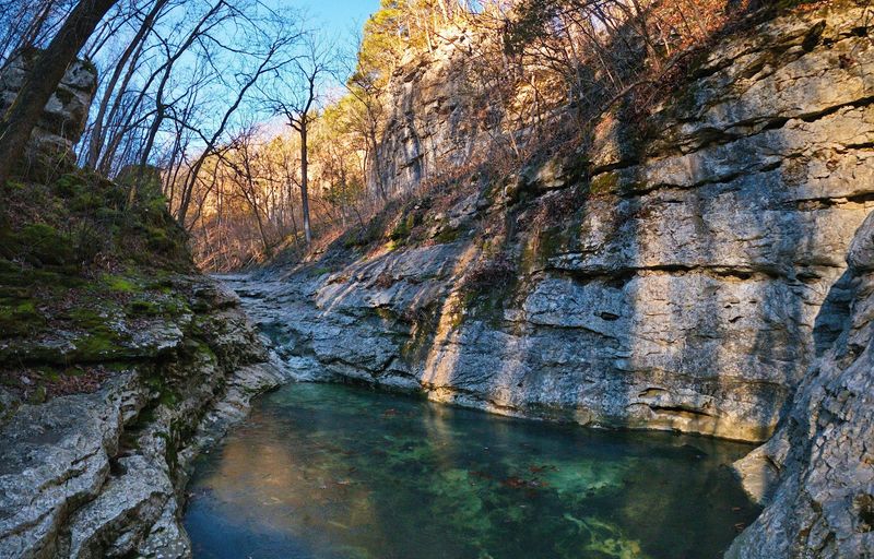 Morning Light Moving Across Cliffs And Creek