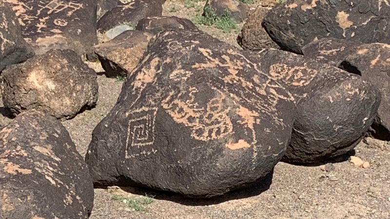 Spirals, Mazes, And Animals Etched Into Dark Stone