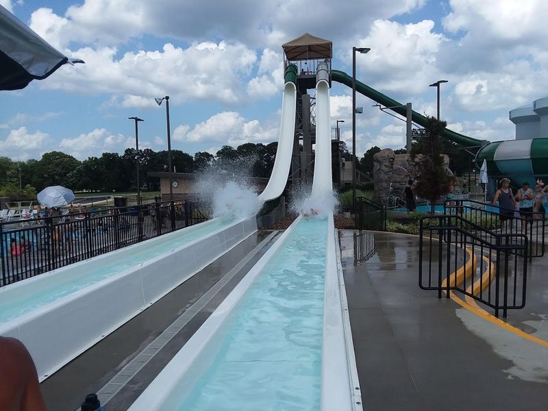 Sunlit Slides Rising Above The Pool Deck