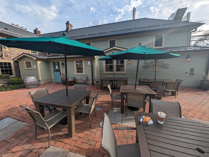 An Outdoor Patio With Picnic Benches Sits Right Behind The Store