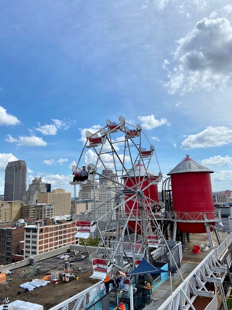 The Rooftop With A Ferris Wheel And A Dangling School Bus