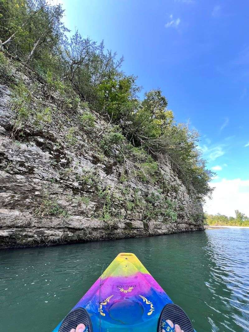 Canoe Drifts Beneath Towering Limestone Bluffs