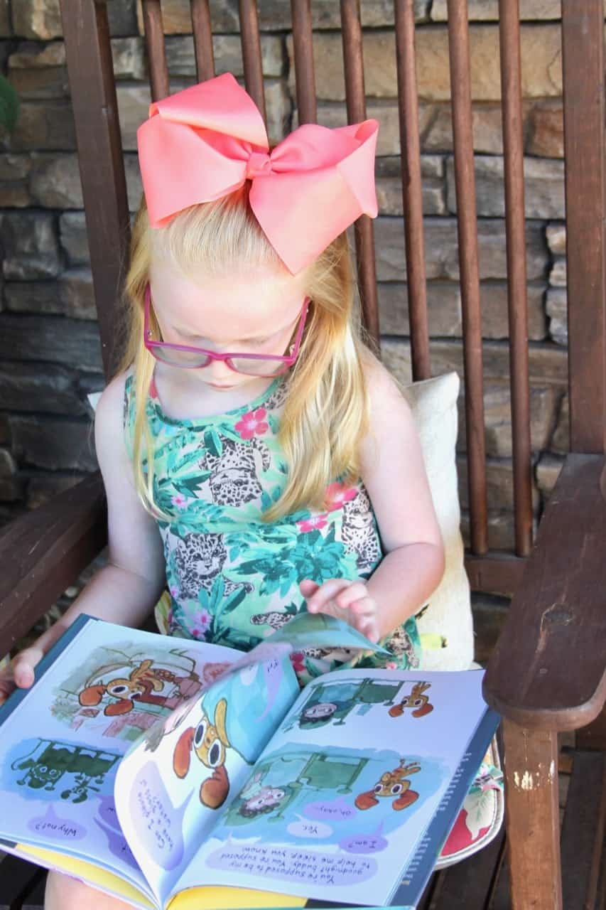child reading book with big bow