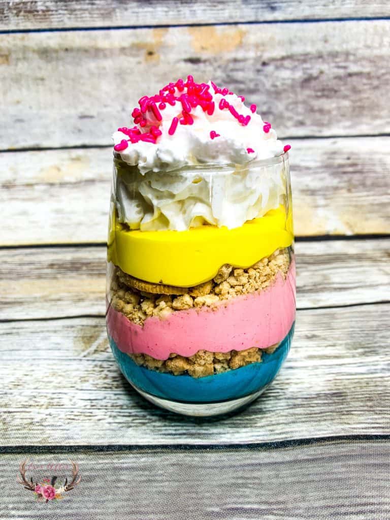 These unicorn parfaits are layers of brightly colored pink, purple and yellow pudding with crushed vanilla cookies in between the decadent layers.