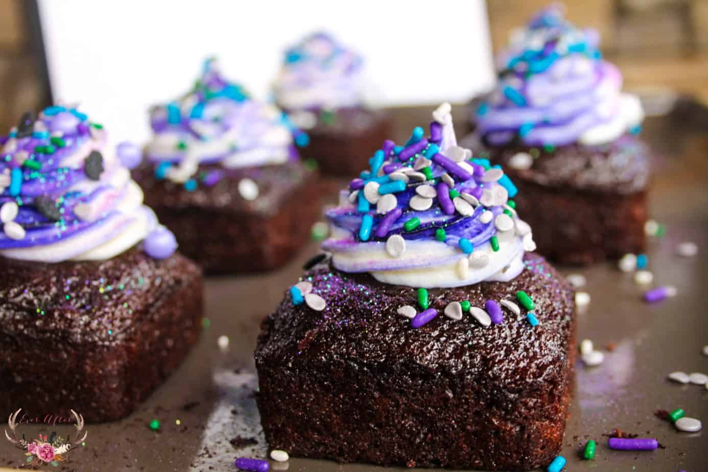 chocolate cake with swirled color frosting purple and white with sprinkles